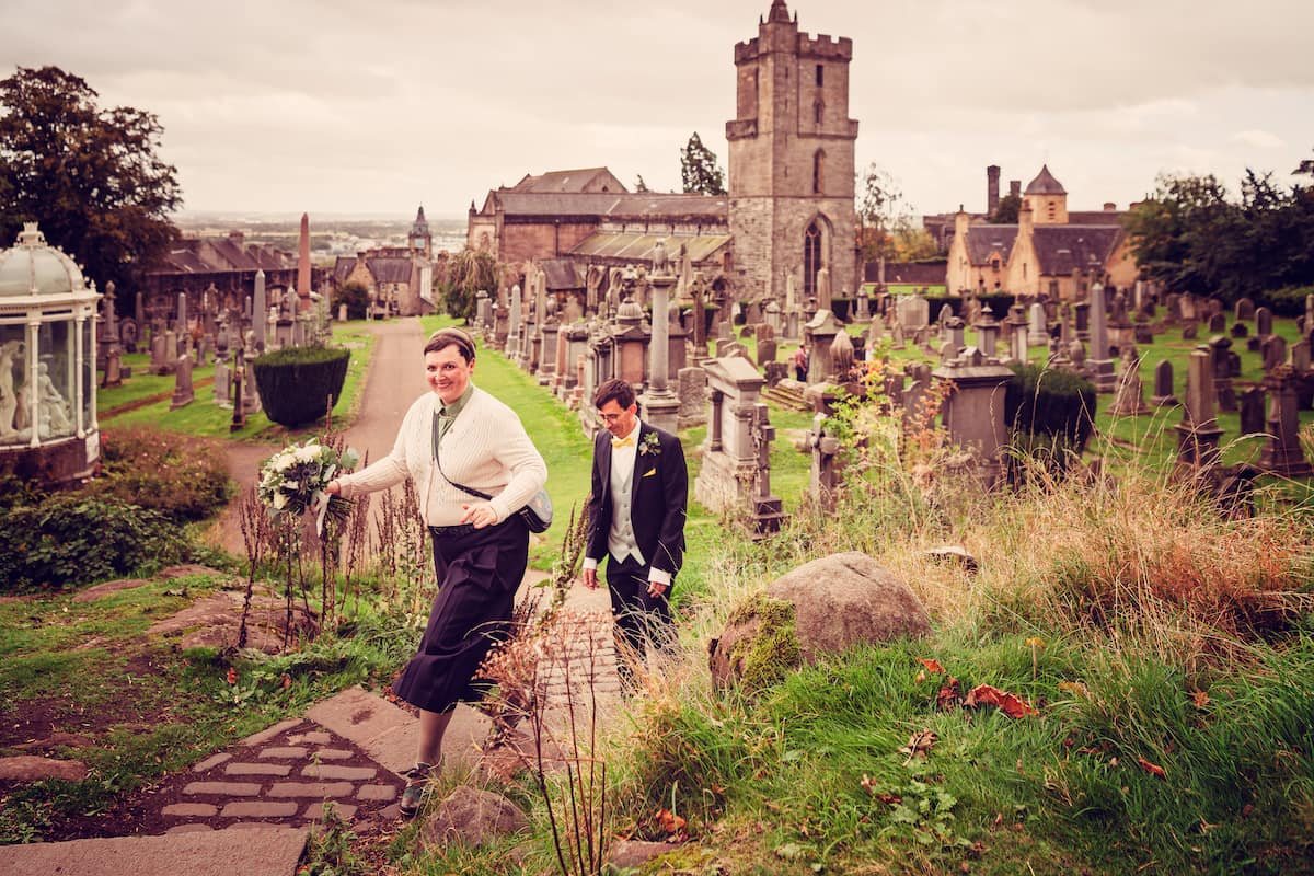 Simone und Jochen auf einem Weg über einen alten Friedhof in Stirling, im Hintergrund eine Kirche mit Turm