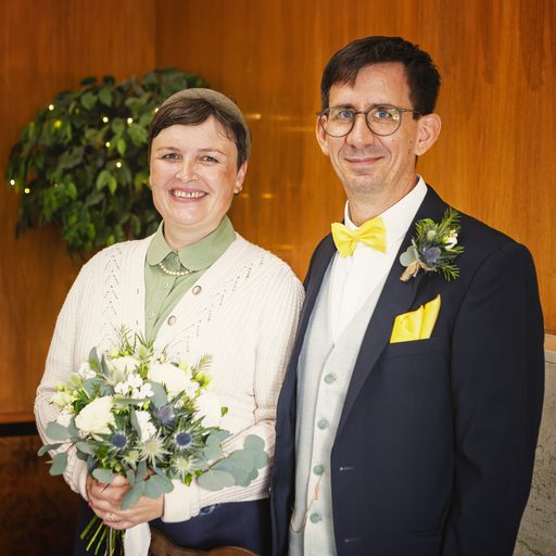 Simone und Jochen in einem holzvertäfelten Raum, Simone hält den Brautstrauß