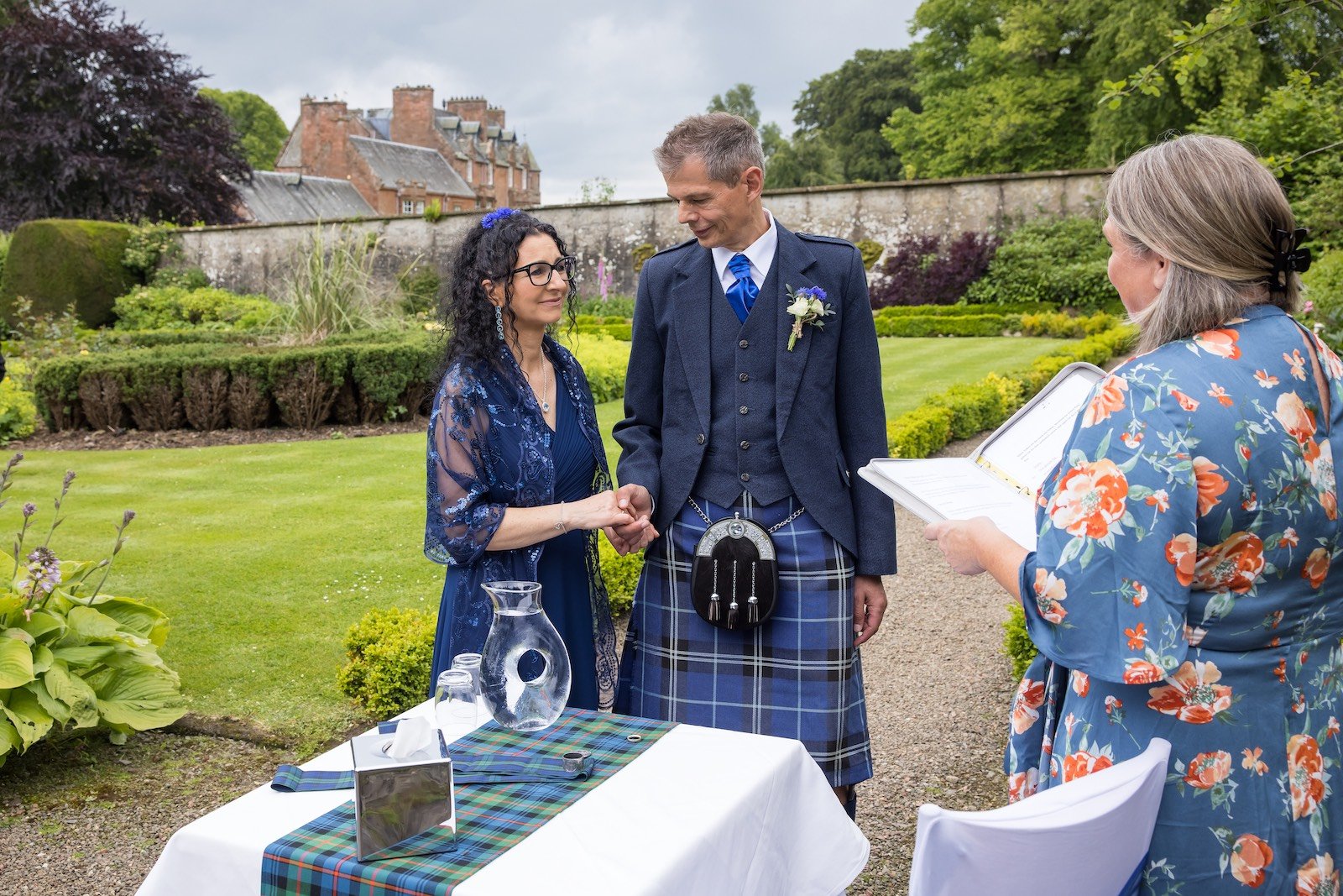 hochzeit-schottland-paar-im-park-mit-dudelsackspieler