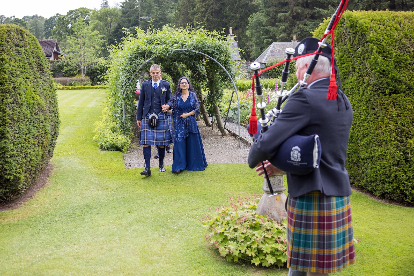 hochzeit-schottland-paar-im-park-mit-dudelsackspieler